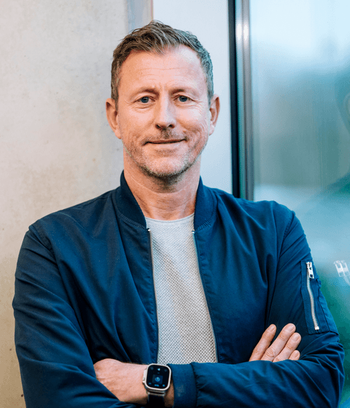 Sympathischer Mann mit entspanntem Lächeln vor moderner Glasfassade – steht für praxisnahe, qualitativ hochwertige VdS-Fortbildungen mit erstklassigen Referenten.