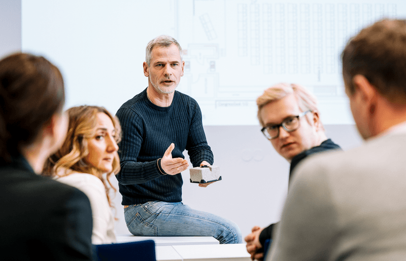Dozent im VdS-Lehrgang erklärt Teilnehmenden praxisnah die Anwendung von Thermografie anhand eines Bauteilmodells vor technischer Skizze.